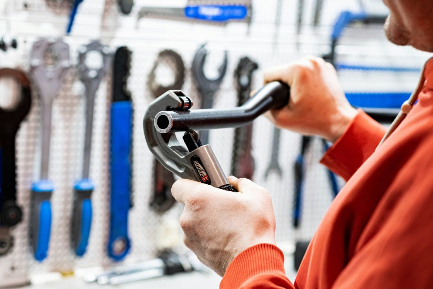 Tradesperson using a pipe cutter in a workshop